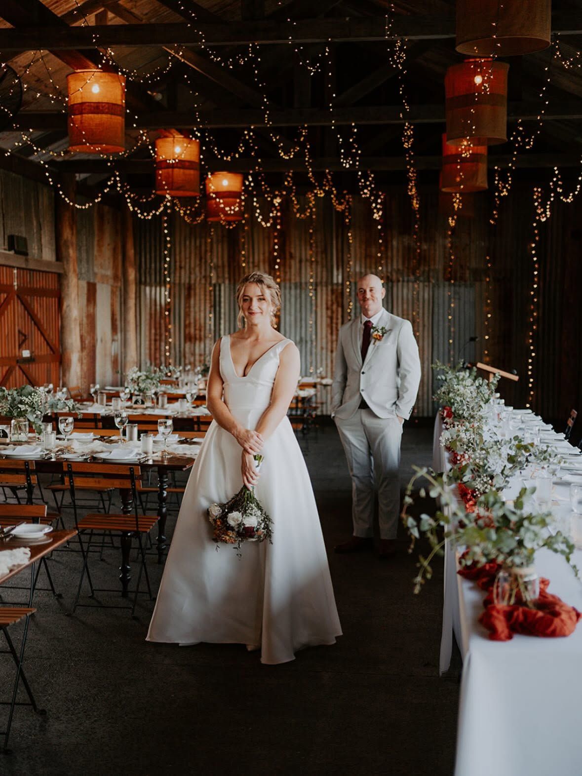 Bride and groom in a fairy-light lit barn reception
