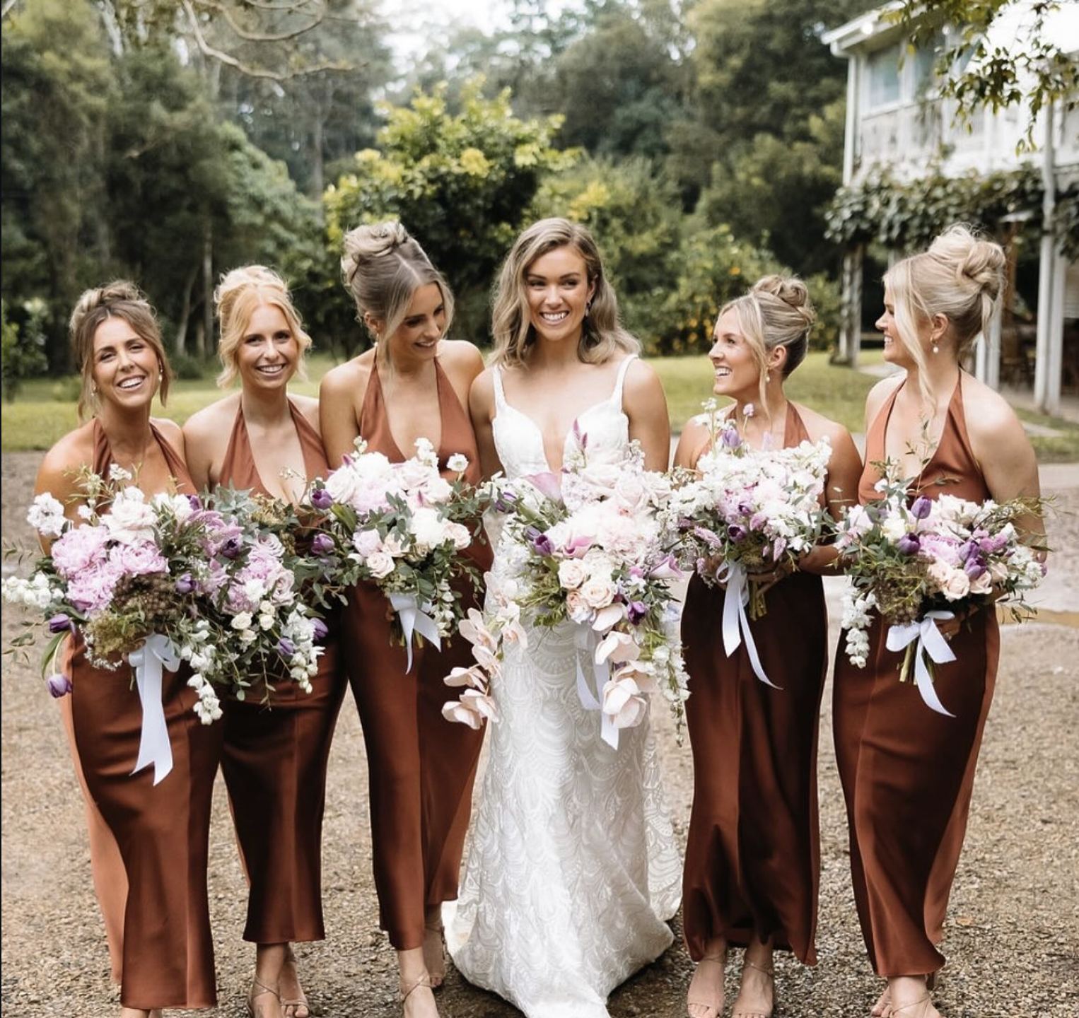 Bridal party in terracotta dresses holding pink and white bouquets