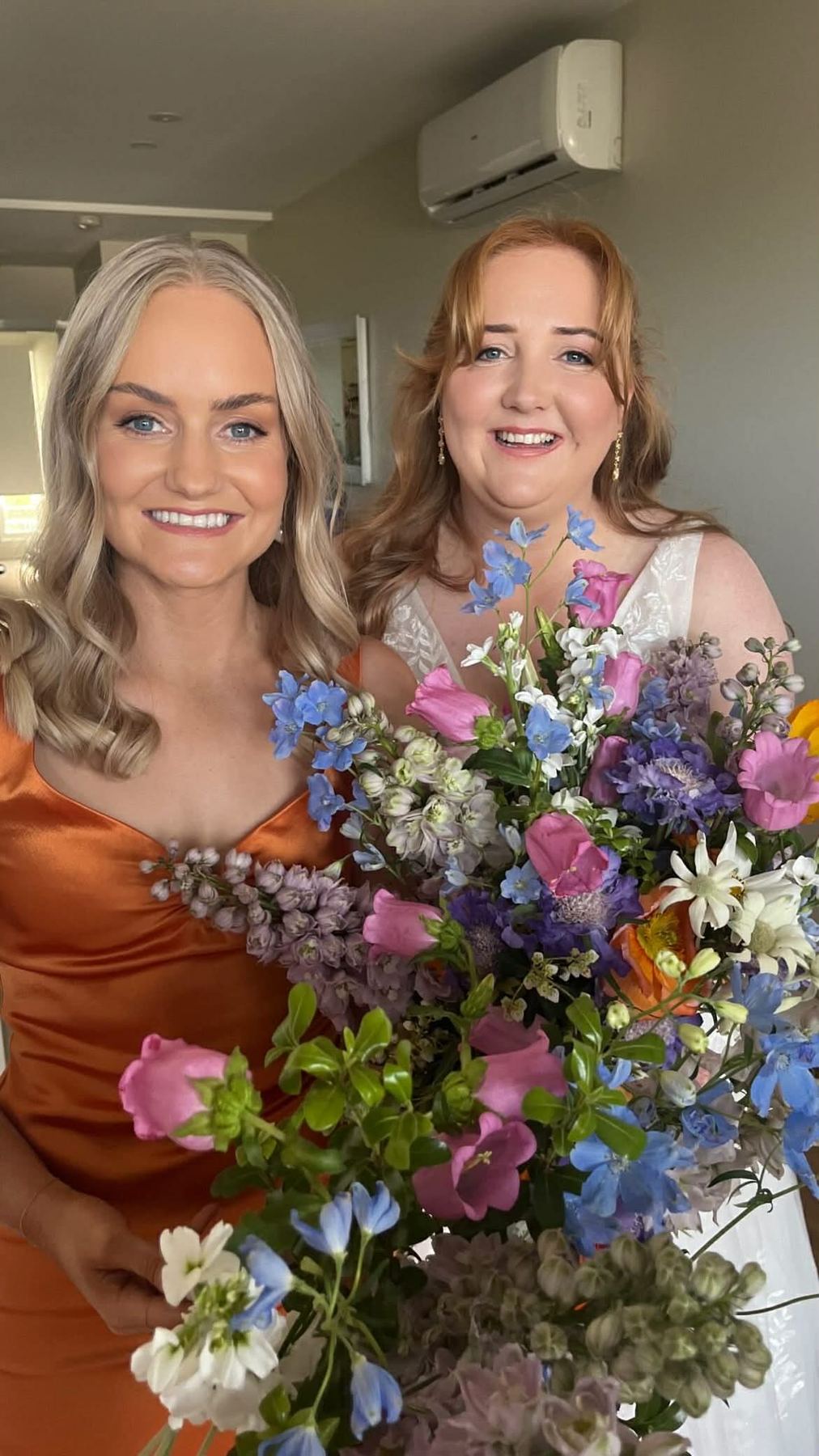 Bridesmaids holding wildflower bouquets while getting ready