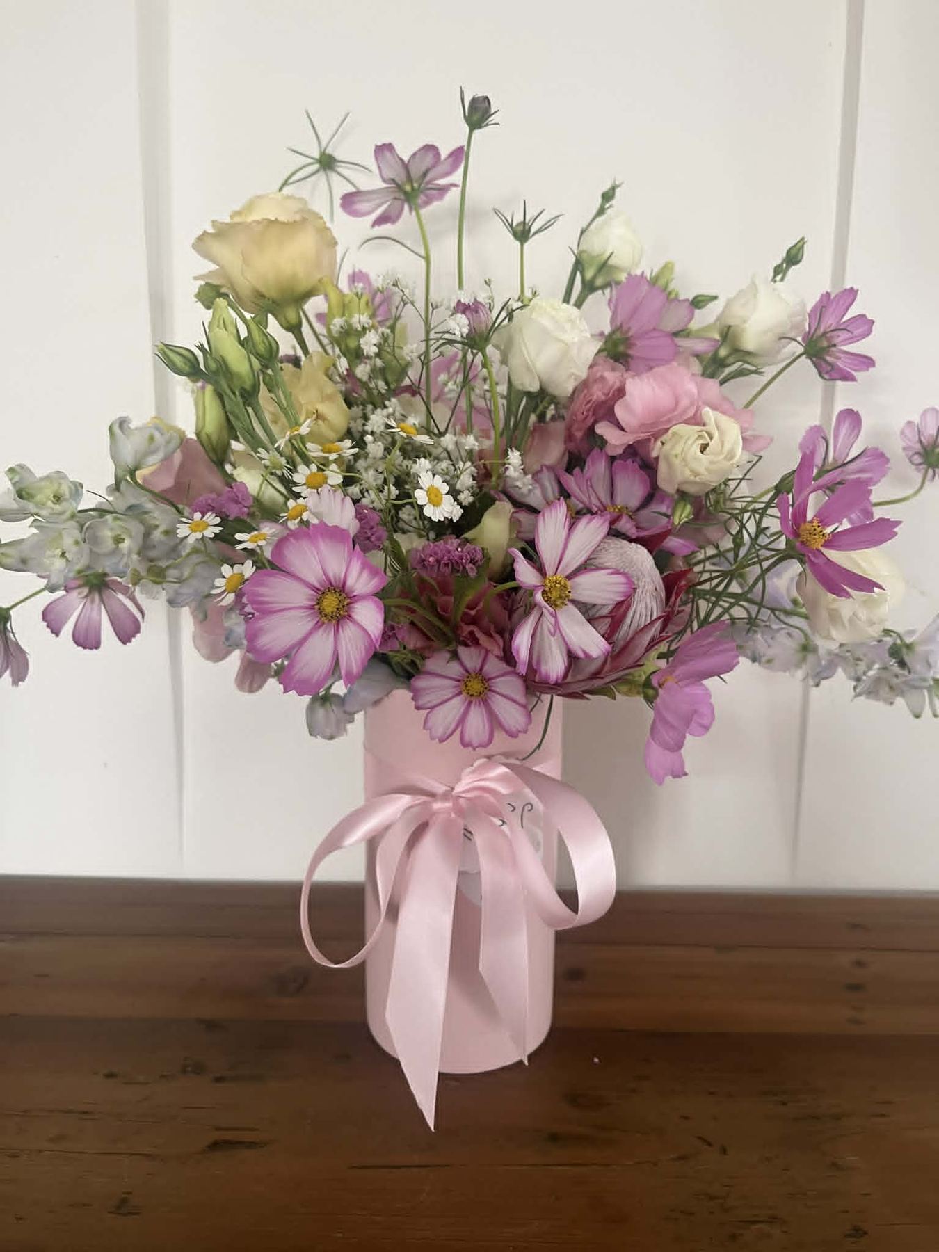 Pink and purple cosmos arrangement in a pink box vase